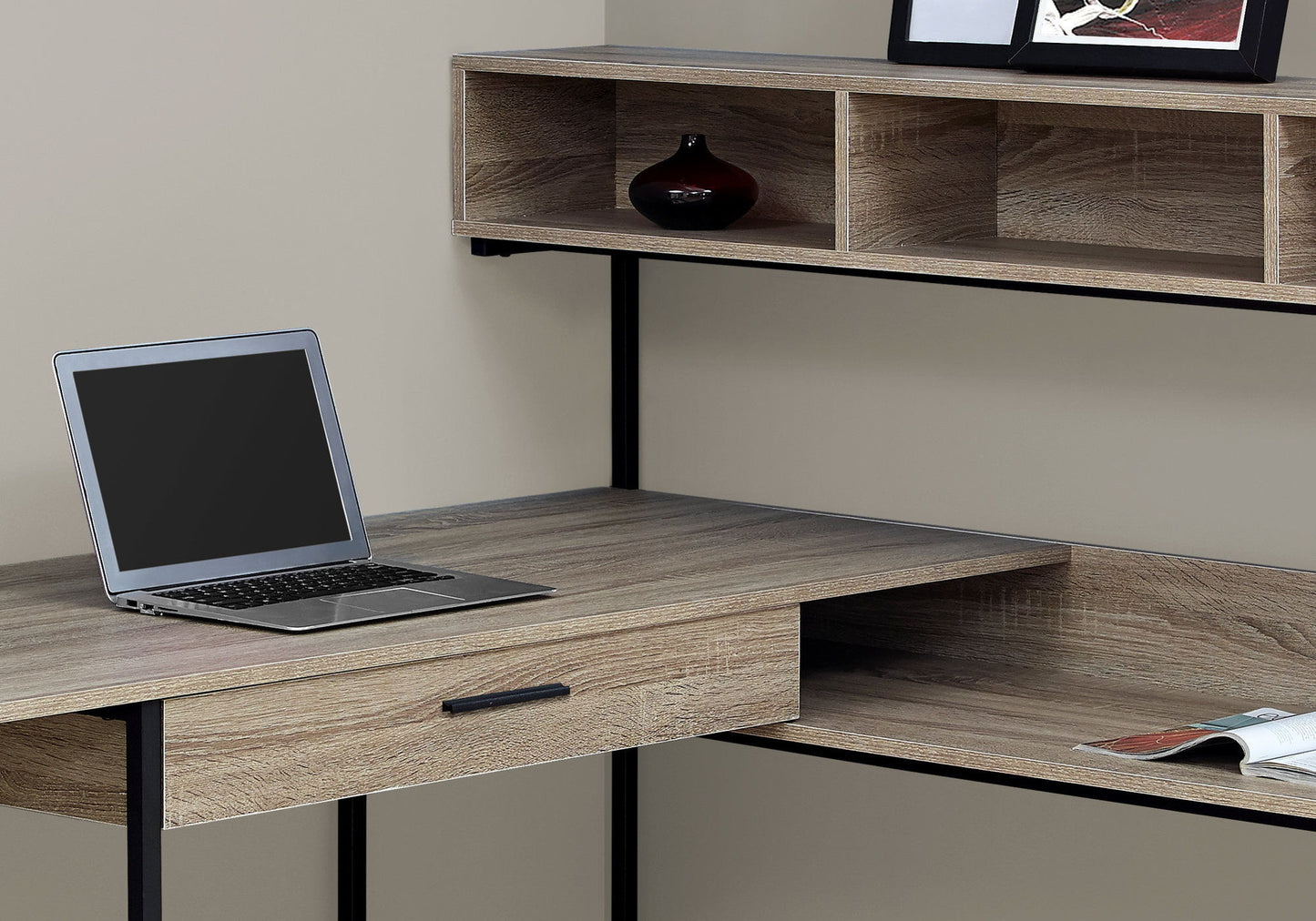 A contemporary L-shaped computer desk with storage drawers, designed for home offices, featuring space for a laptop and decor, placed against a light-colored wall.