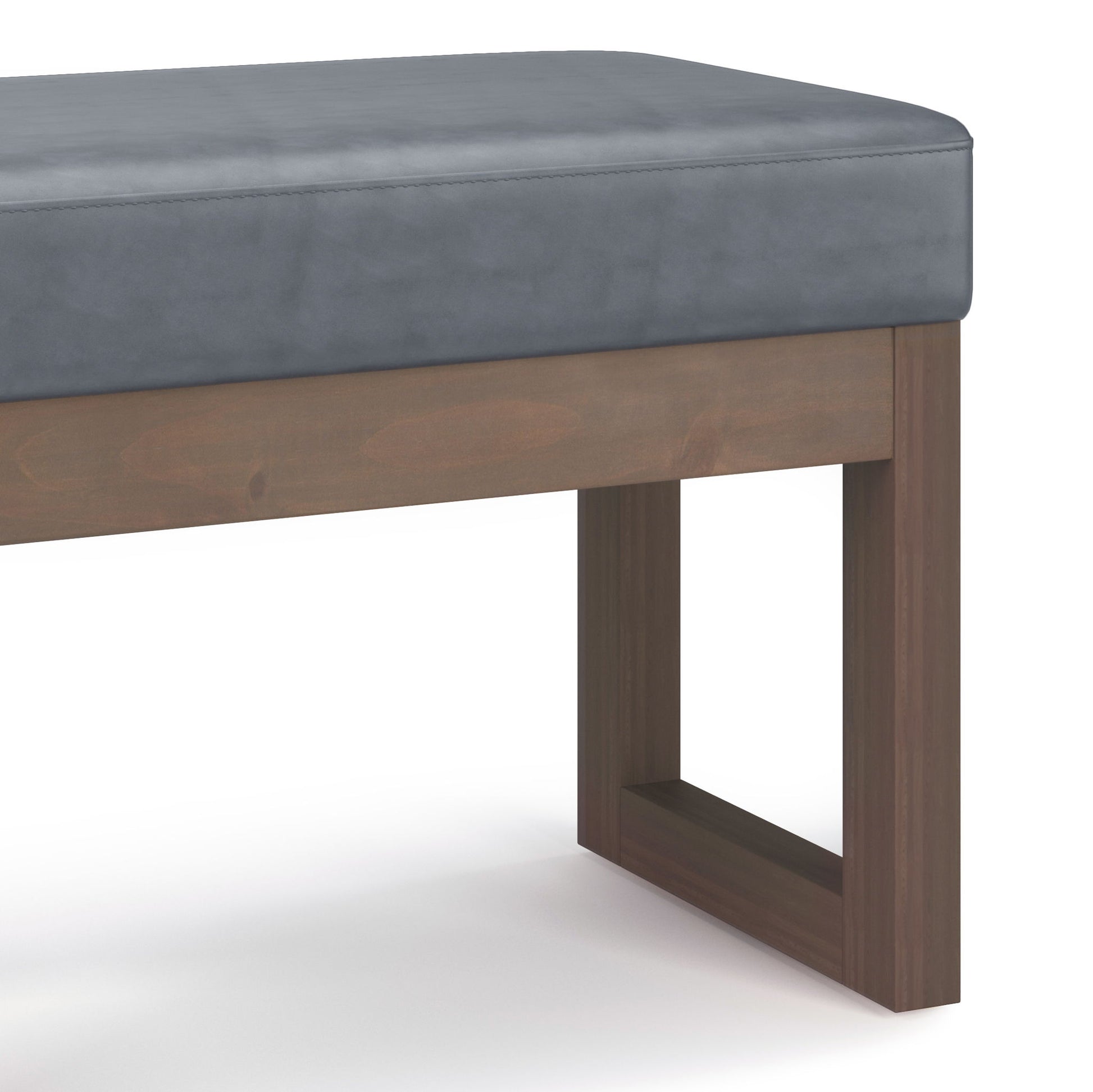A close-up of the Milltown - Upholstered Ottoman Bench featuring a gray cushioned seat and a rectangular wooden base with clean lines, set against a white background.