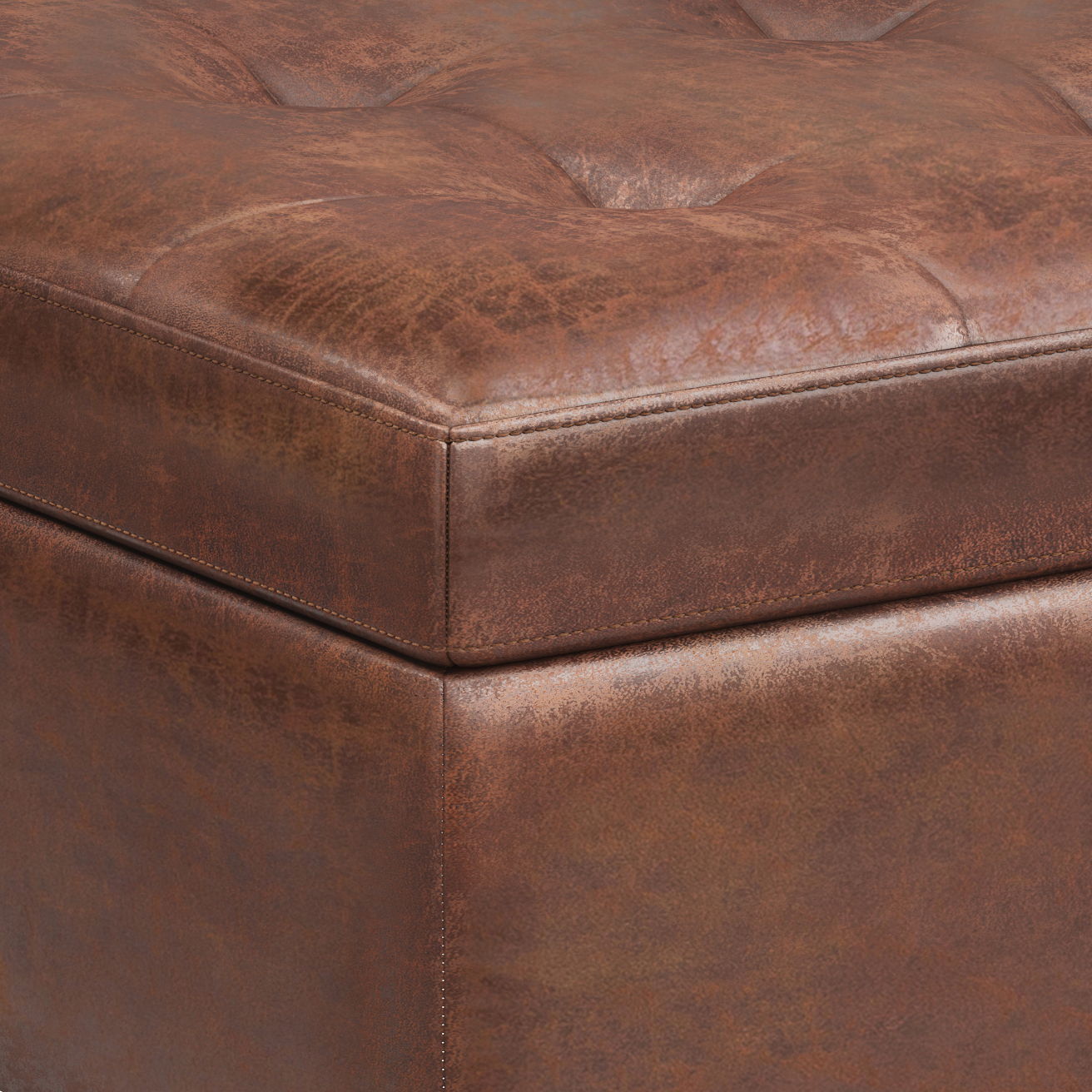 Close-up of the corner of the Shay - Large Square Coffee Table Storage Ottoman, featuring brown tufted leather, visible stitching, and a distressed mid-century textured finish.