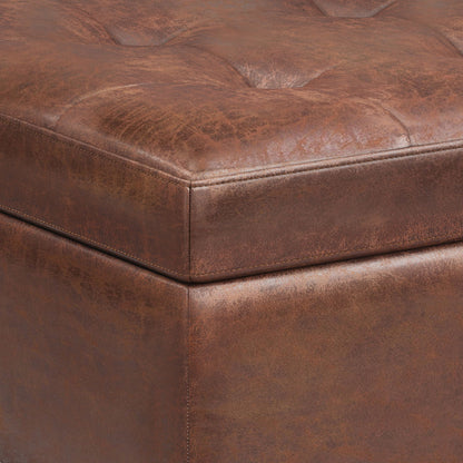 Close-up of the corner of the Shay - Large Square Coffee Table Storage Ottoman, featuring brown tufted leather, visible stitching, and a distressed mid-century textured finish.