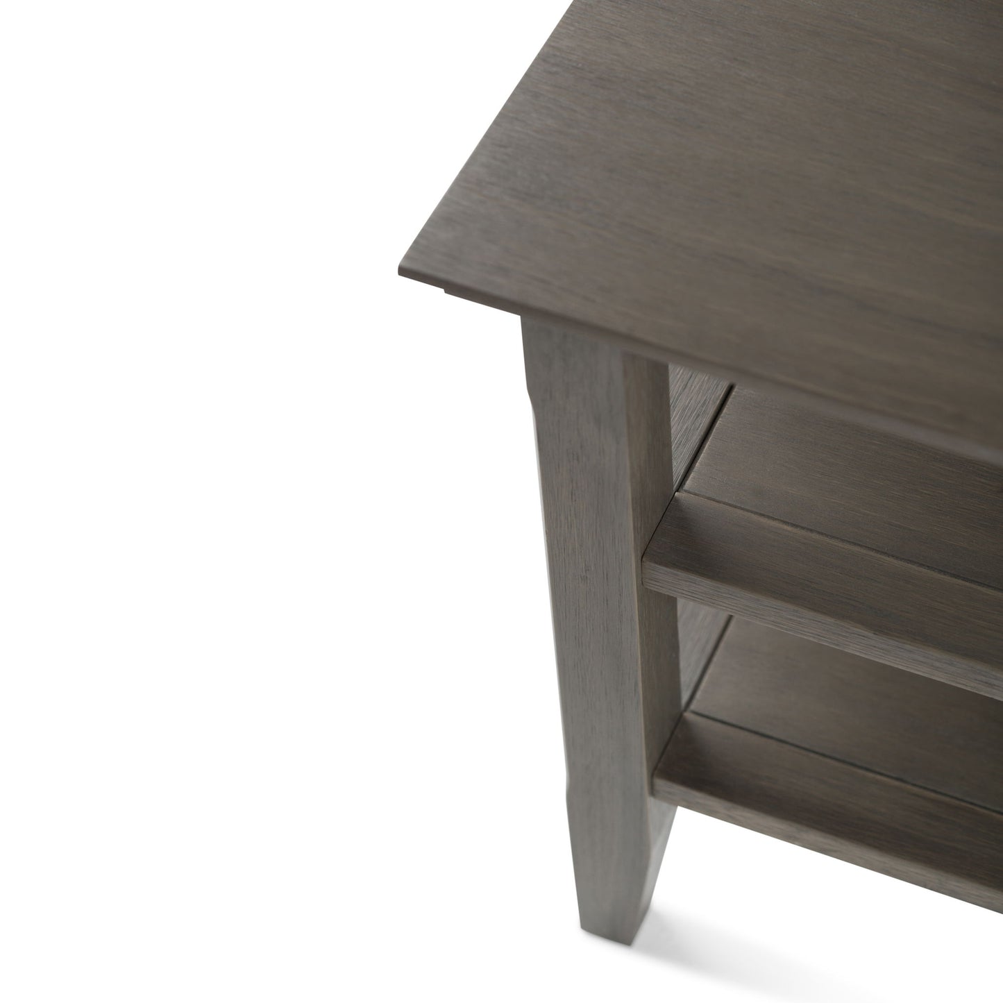 Close-up of the Acadian - Handcrafted End Table corner, highlighting its grayish finish, tabletop, supporting leg, and two lower shelves.
