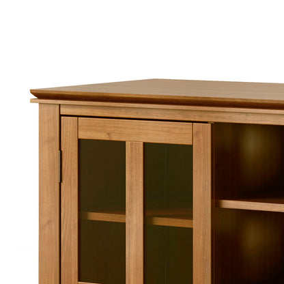 A close-up of the Artisan Handcrafted Tall TV Media Stand, featuring glass panel doors, visible shelving inside, a smooth light brown finish, and a simple modern design.