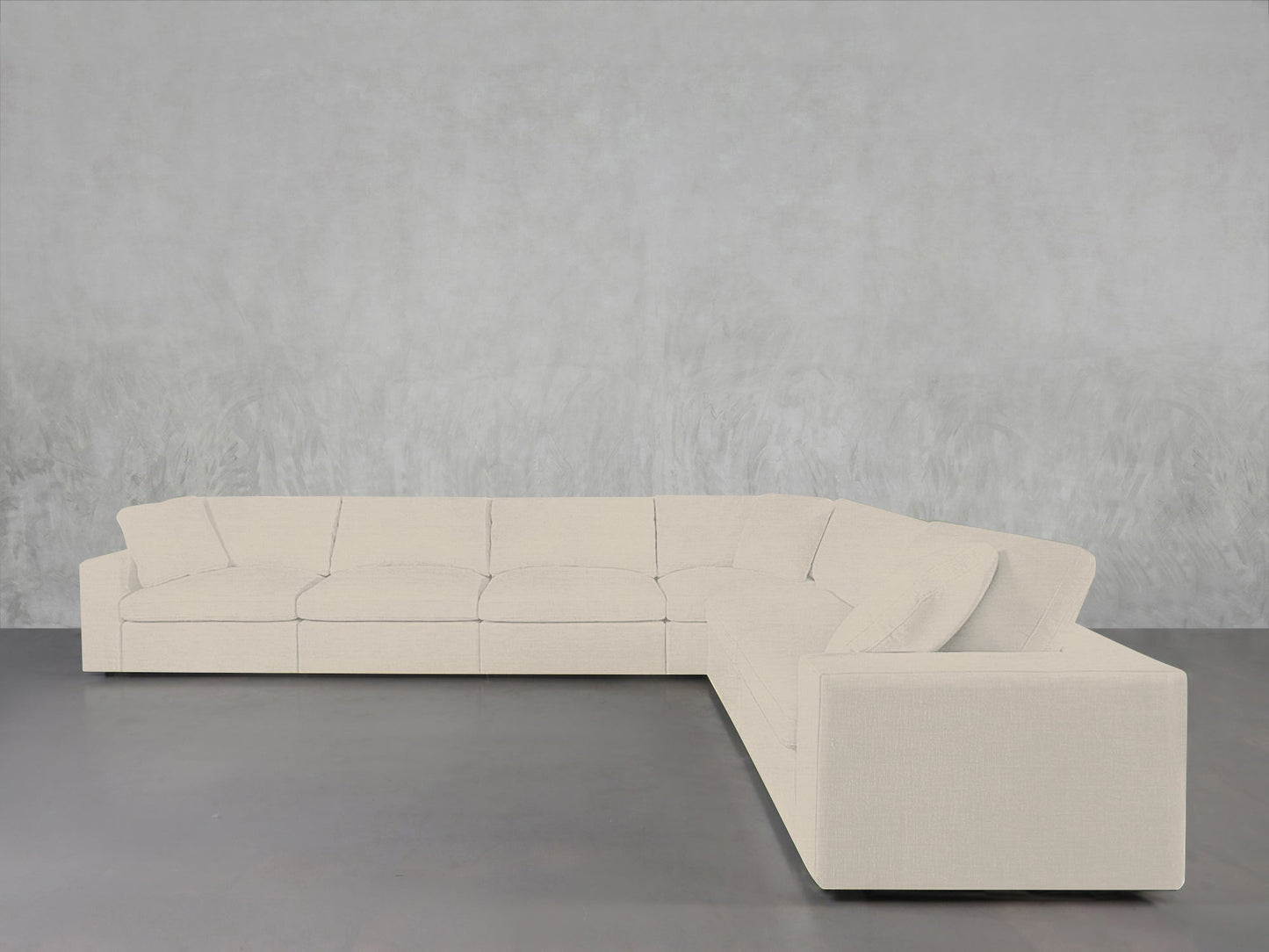 A 6-Seat Modular Corner Sectional in off-white sits on a smooth gray floor against a light gray textured wall, creating a minimalist and modern interior.