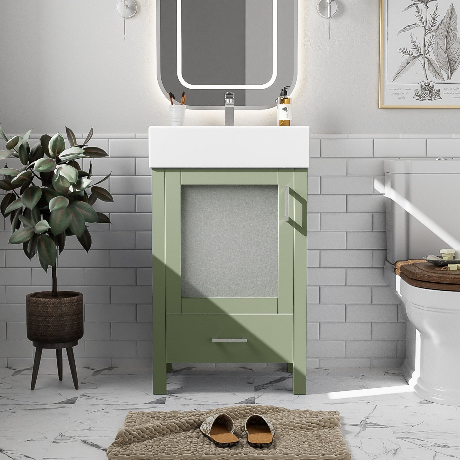 A small bathroom features the Bathroom Vanity With Ceramic Sink And Ample Storage, a round mirror, potted plant, white subway tiles, toilet, framed botanical print, marble floor, and brown slippers on a textured mat.