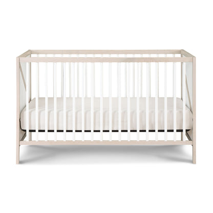 The Pixie Zen 3-in-1 Crib in Walnut, featuring white slats and a matching white mattress, is displayed against a plain white background.