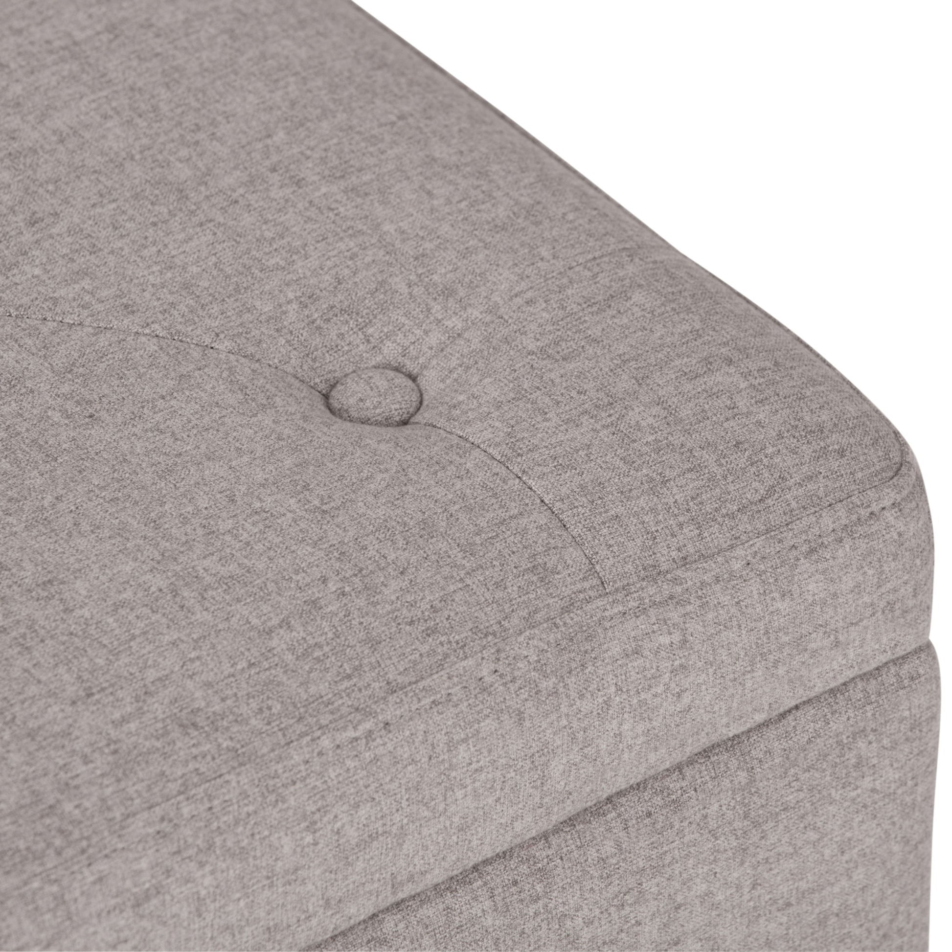 Close-up of the Hamilton - Upholstered Storage Ottoman in light gray, featuring a button-tufted cushion, stitched seam, soft fabric texture, and visible corner detail.