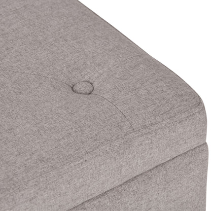 Close-up of the Hamilton - Upholstered Storage Ottoman in light gray, featuring a button-tufted cushion, stitched seam, soft fabric texture, and visible corner detail.