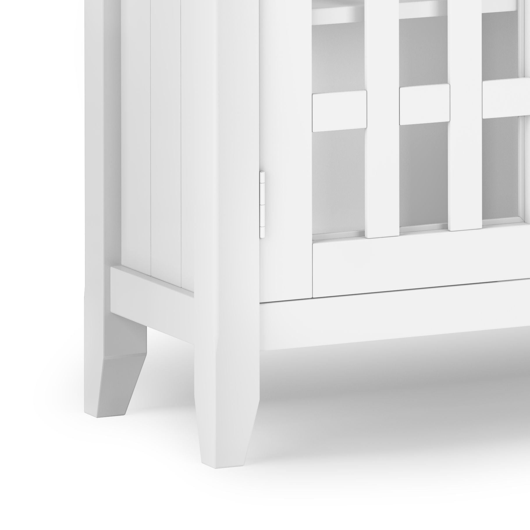 Close-up of the bottom corner of the Bedford - Storage Media Cabinet, showing its white finish, vertical slats, sturdy legs, and part of the side and front panels.