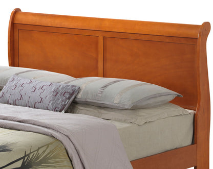 A Panel Sleigh Bed is neatly made with light gray sheets, a gray comforter, and several pillows, including a decorative geometric-patterned pillow.
