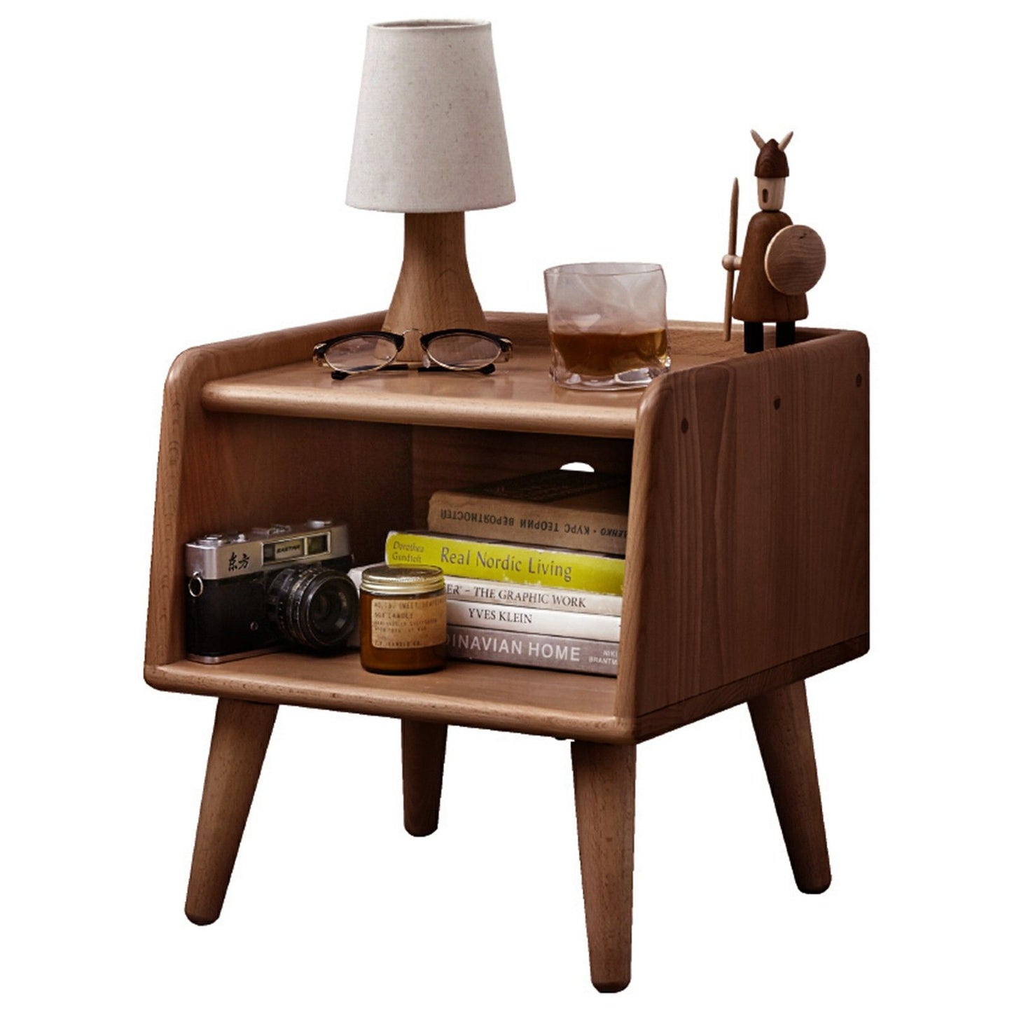 The Bedside Cabinet, Modern Simple Nightstands European Beech, features angled legs and shelves holding a lamp, drink, wooden animal figurine, vintage camera, books, and jars—perfect for a mid-century modern look.