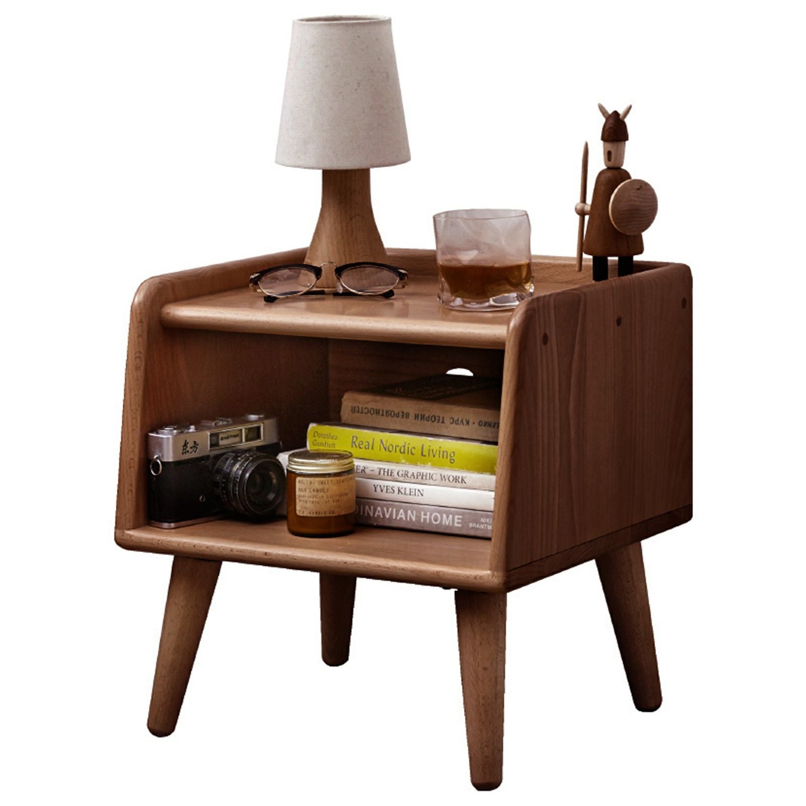 The Bedside Cabinet, Modern Simple Nightstands European Beech, features angled legs and shelves holding a lamp, drink, wooden animal figurine, vintage camera, books, and jars—perfect for a mid-century modern look.