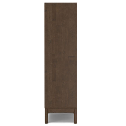 The Harper Handcrafted Bookcase With Storage is displayed from the side, featuring a tall, rectangular silhouette in dark brown wood with a flat side panel and four short legs.