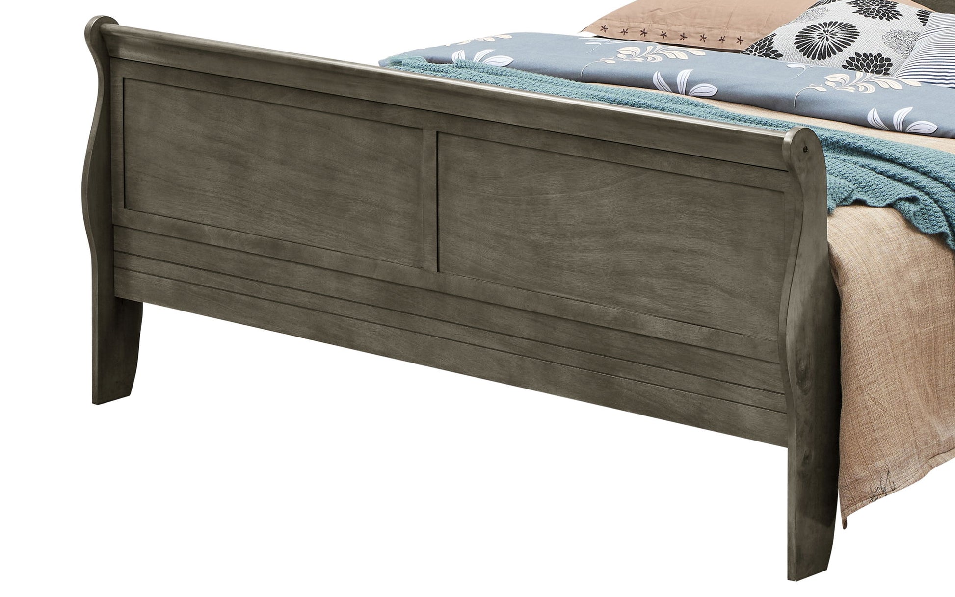 A close-up of the Panel Sleigh Bed’s wooden footboard in a dark gray finish, with a neatly made bed featuring a blue knit blanket and floral bedding.