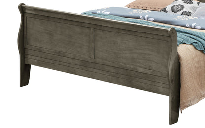 A close-up of the Panel Sleigh Bed’s wooden footboard in a dark gray finish, with a neatly made bed featuring a blue knit blanket and floral bedding.