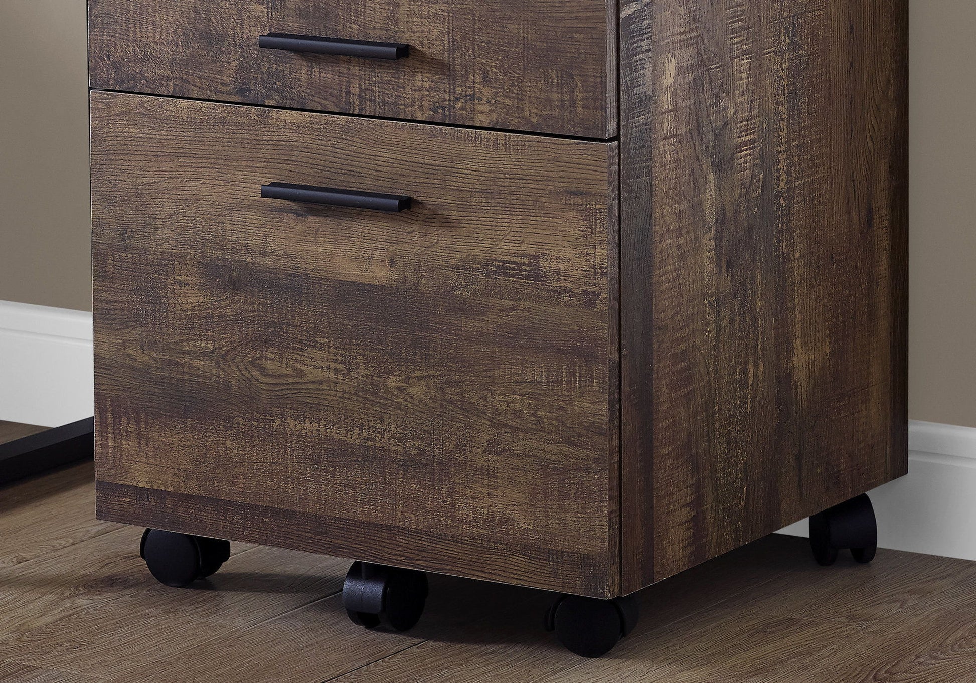 A close-up of the File Cabinet Rolling Mobile Storage Drawers Printer Stand For Office, featuring two drawers with black handles and black caster wheels, is shown on a hardwood floor against a beige wall.
