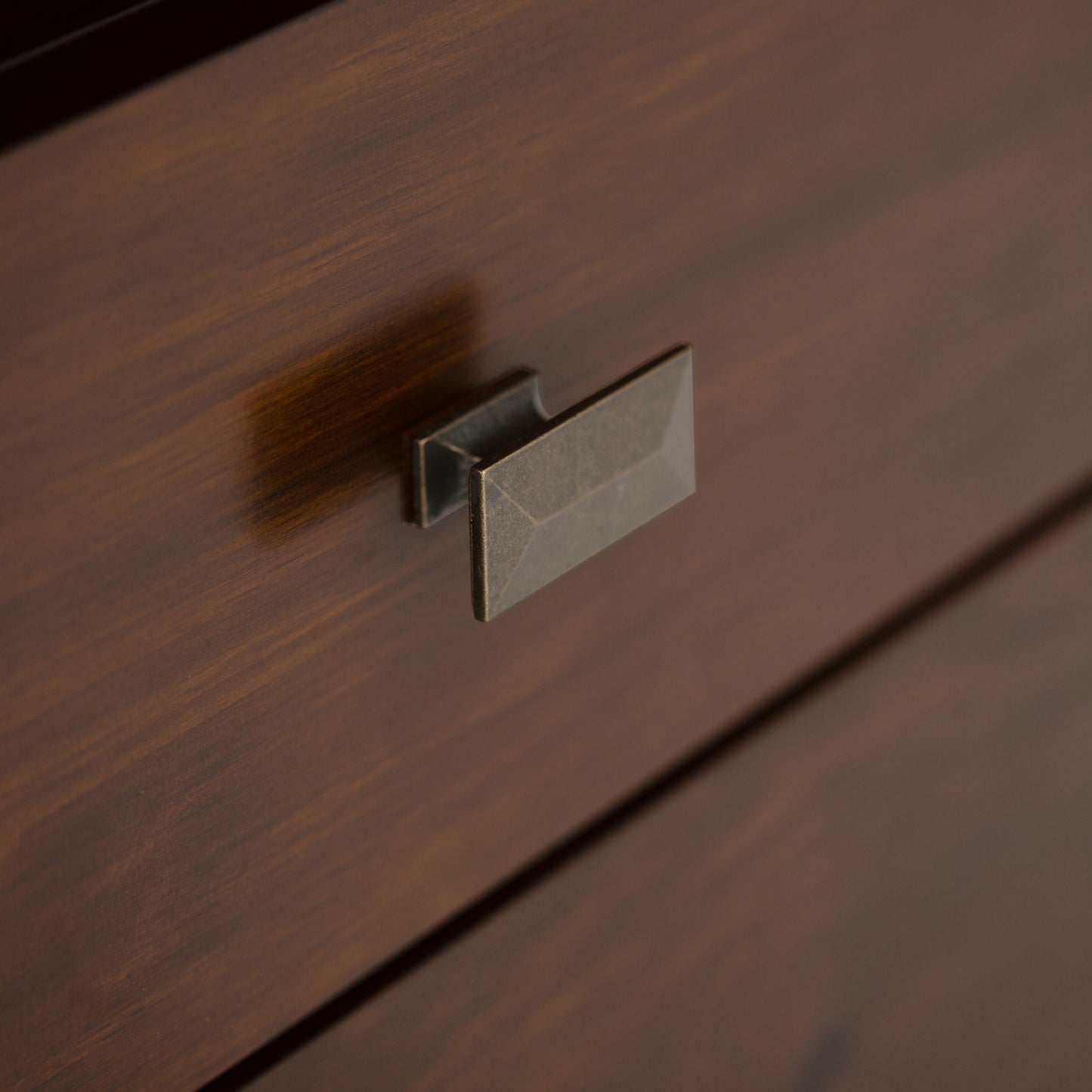 Close-up of the Artisan - Handcrafted, Tall TV Media Stand's wooden drawer, featuring a rectangular metallic handle with a brushed finish and visible wood grain texture.