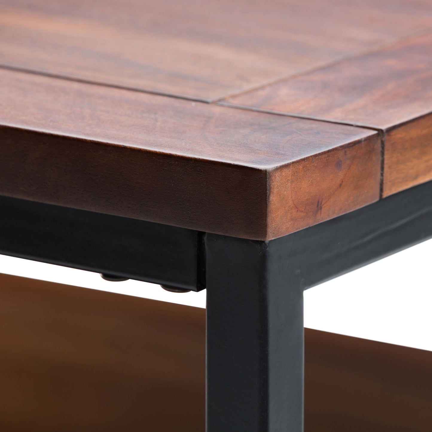 Close-up of the Skyler - Handcrafted Table’s corner, featuring smooth wood grain and a sturdy dark metal frame, highlighted against a white background.