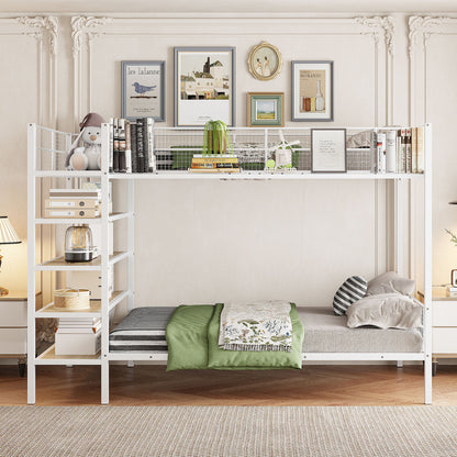 The Bunk Bed With 5 Tier Shelves features white metal framing and shelves displaying books, plants, and decor. The lower bed sports green and gray bedding, surrounded by framed artwork on a light wall in a stylish, cozy room.