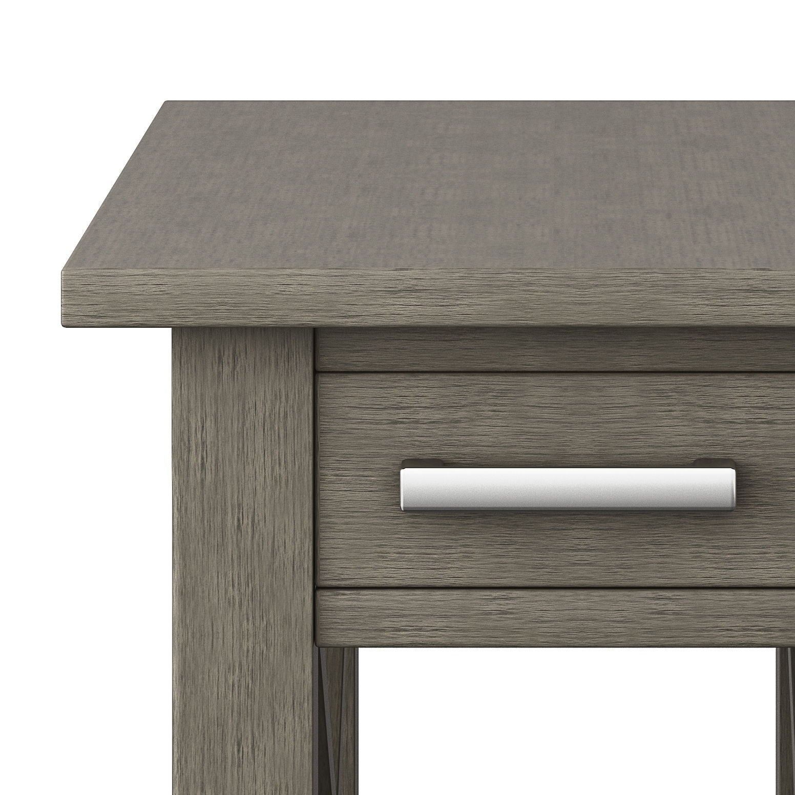 Close-up of the corner of the Kitchener - Handcrafted Table in gray wood, featuring a visible wood grain and a drawer with a silver handle.
