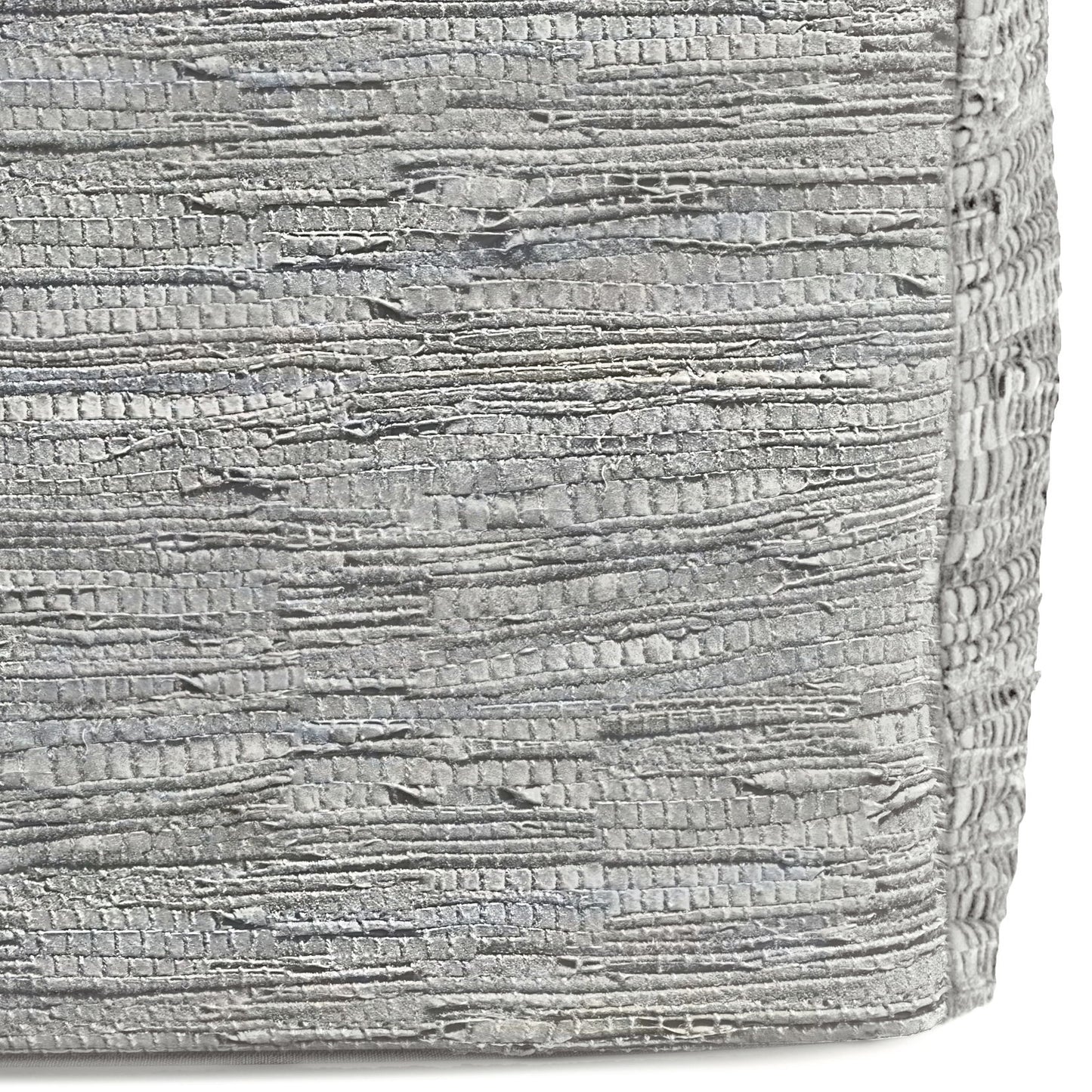 Close-up of the Fredrik - Handcrafted Square Pouf's textured silver fabric, featuring horizontal, irregular ridges and a metallic sheen. The surface is slightly rough and reflective, highlighting its unique artisanal design.