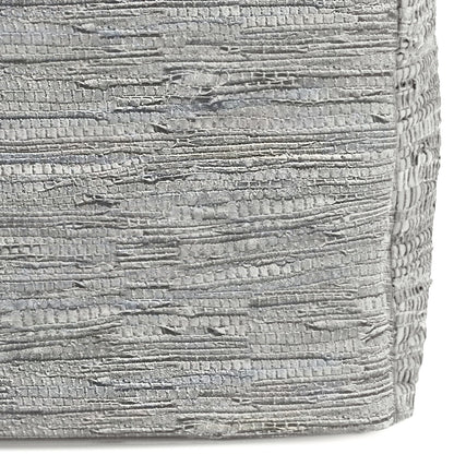Close-up of the Fredrik - Handcrafted Square Pouf's textured silver fabric, featuring horizontal, irregular ridges and a metallic sheen. The surface is slightly rough and reflective, highlighting its unique artisanal design.