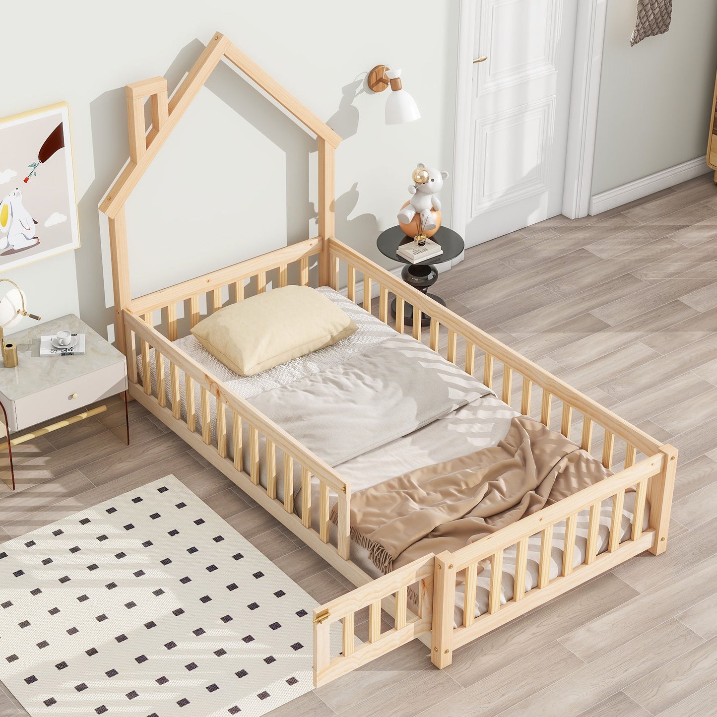 The House-Shaped Headboard Floor Bed With Fence features a natural wood frame, light bedding, a small pillow, and a safety rail. The room has a light palette, dark-dotted rug, and bedside table with toys.