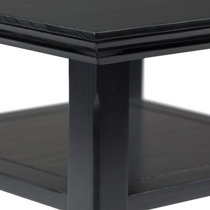 Close-up of the Acadian - Handcrafted End Table, highlighting its black wooden finish, thick square leg, and lower shelf with a clean modern design against a white background.