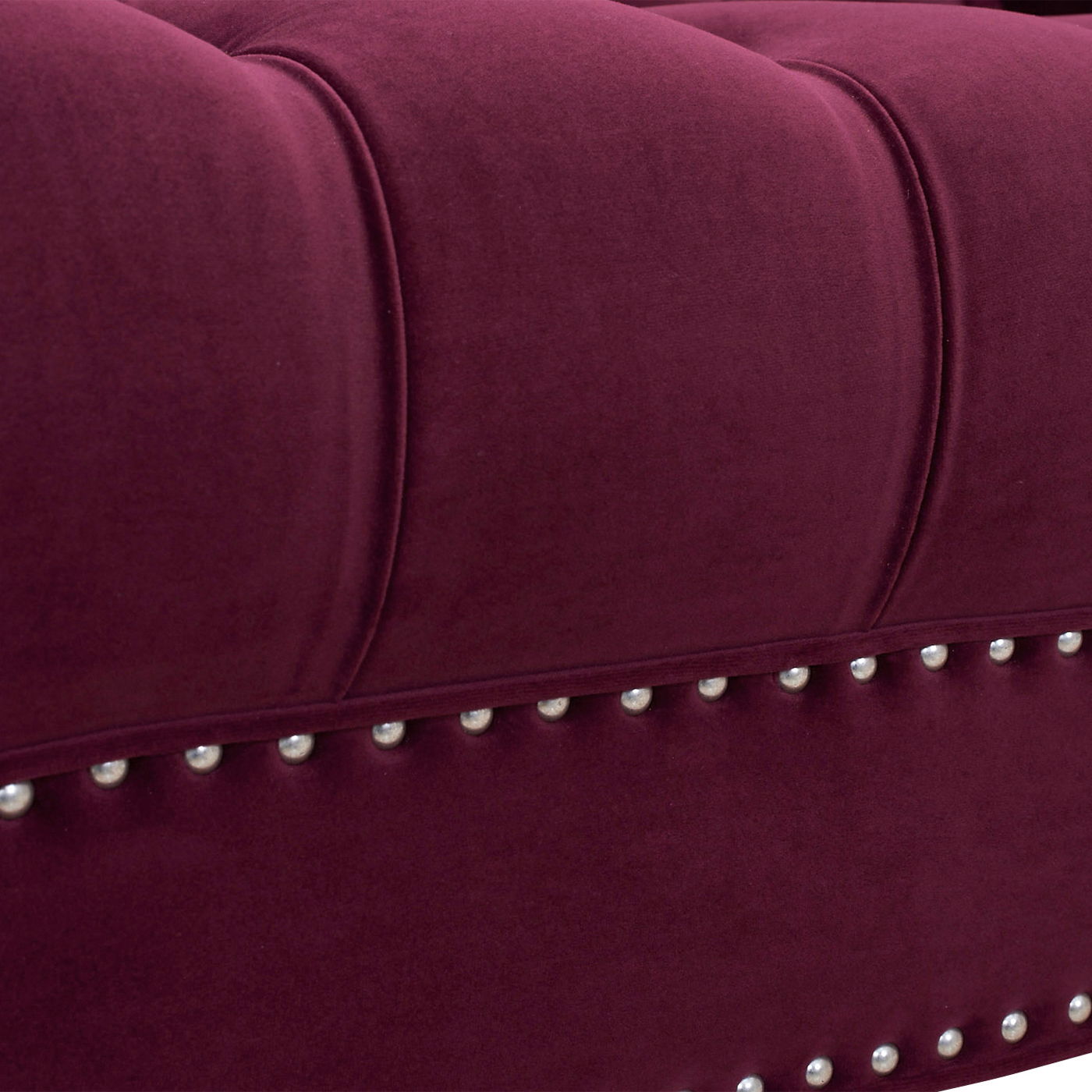 Close-up of the La Rosa - Victorian Chesterfield Tufted Sofa featuring plush deep burgundy upholstery, vertical stitching, and a row of silver decorative studs along the edge.