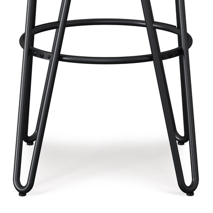 Close-up of the black metal legs and footrest ring of the Simeon Multifunctional Metal Stool With Wood Seat. The legs are rounded and triangular, joined by a circular support, shown against a white background.