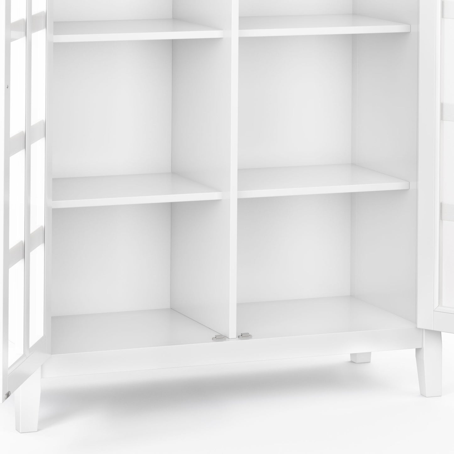 A close-up of the Acadian - Medium Storage Cabinet, Handcrafted, featuring four shelves and glass-paneled doors, empty and standing on short legs against a plain background.