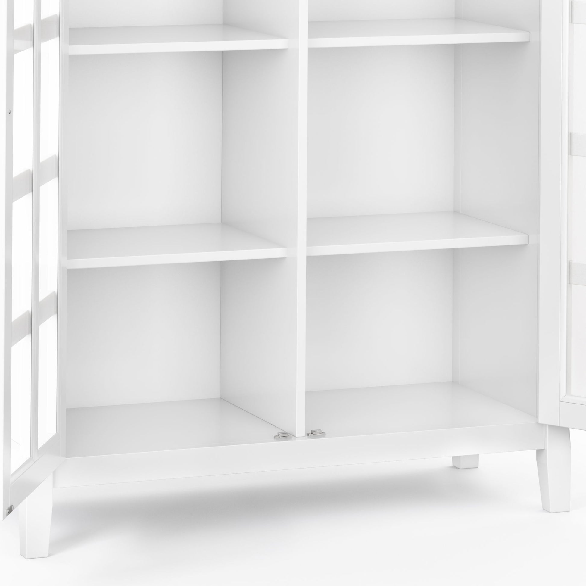 A close-up of the Acadian - Medium Storage Cabinet, Handcrafted, featuring four shelves and glass-paneled doors, empty and standing on short legs against a plain background.