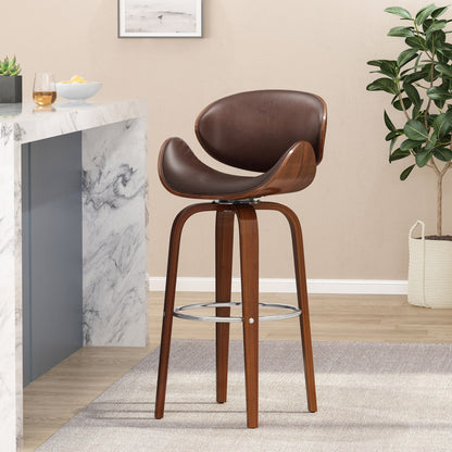 The Lumos Mid Century Modern Upholstered Swivel Barstool, featuring a curved brown leather seat, wooden legs, and metal footrest, sits on a gray rug by a marble countertop with a plant and wall art in the background.