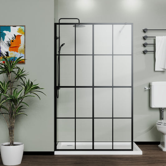 A modern bathroom with the Shower Screen Walk In Wet Room - Black featuring a black grid frame, wall-mounted showerhead, white toilet, towel on a rail, potted plant, and abstract art on a green wall.
