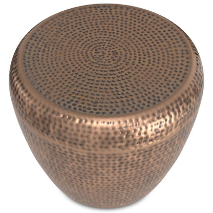 The Preston - Handcrafted Metal Side Table features a round, metallic design with a hammered copper finish and a textured, dimpled surface.