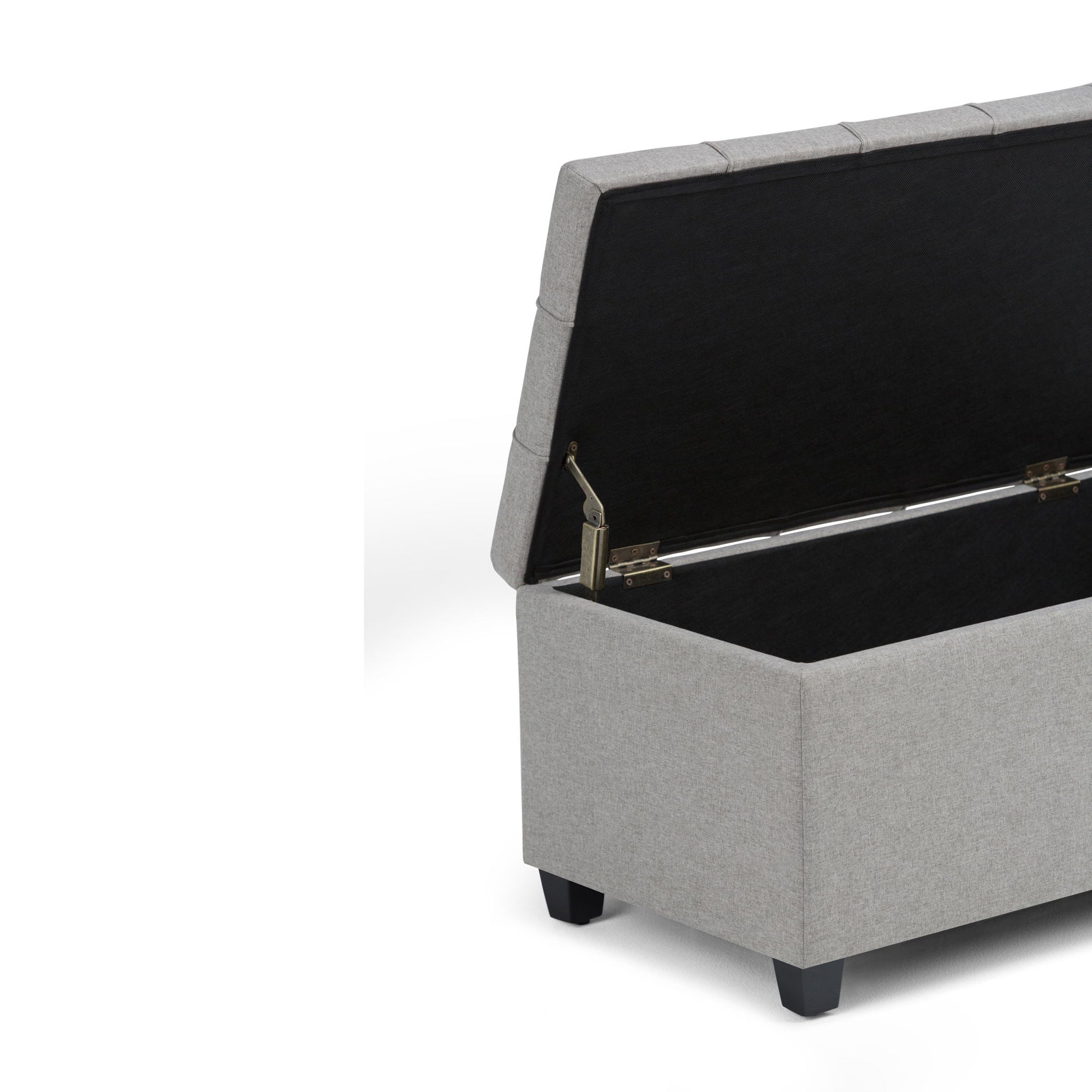The Sienna - Upholstered Storage Ottoman Bench in light gray features a hinged lid that opens to a spacious black interior. It stands on short black legs and is shown against a white background.