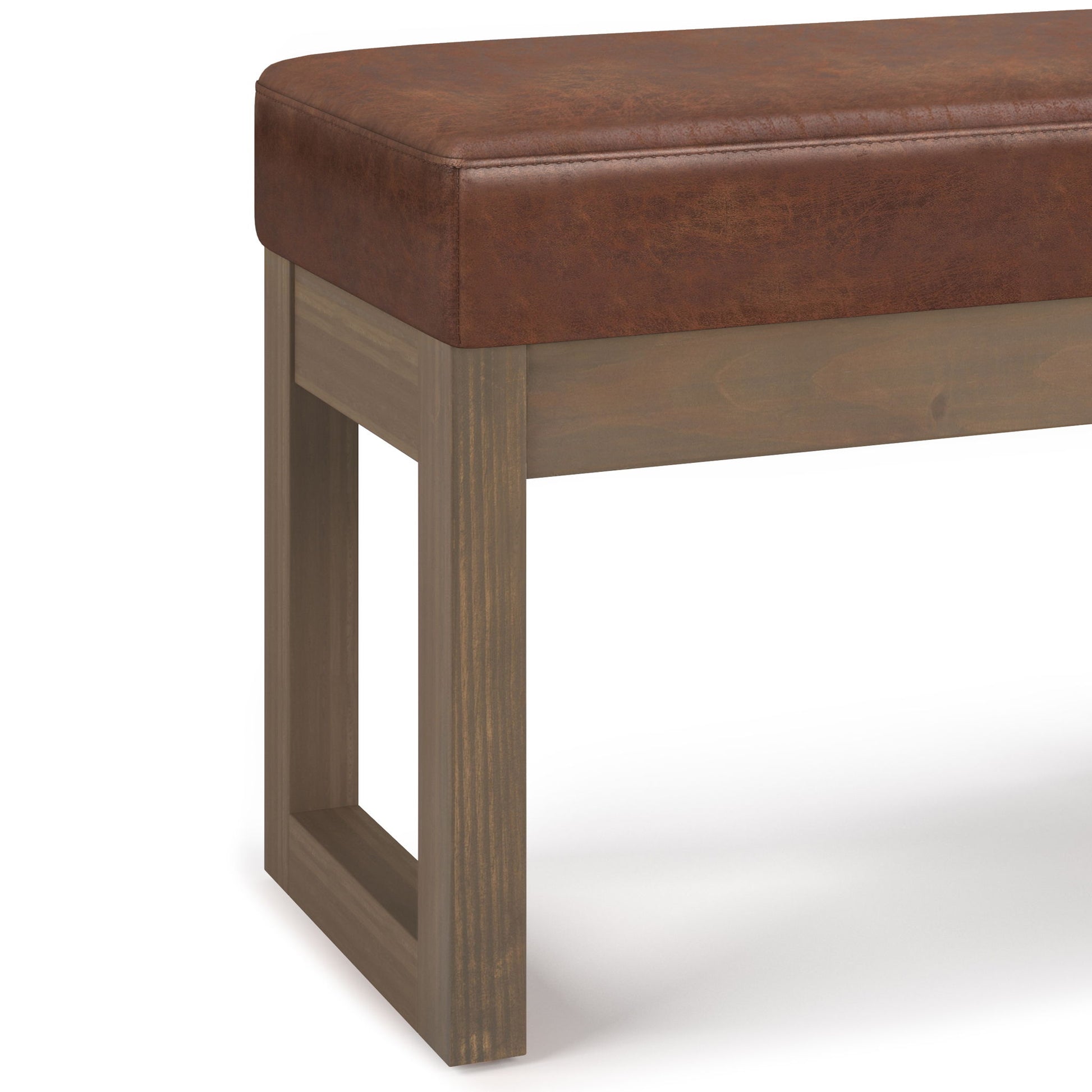 The Milltown Upholstered Ottoman Bench features a brown faux leather cushioned seat and a rectangular wooden base with an open square leg design.