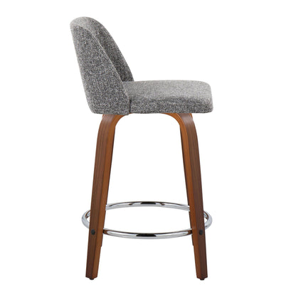 The Toriano counter stool, sold in a set of two, features a modern design with a curved gray fabric seat and backrest. Its wooden frame has slightly angled legs and is complemented by a circular chrome footrest. Side view available.