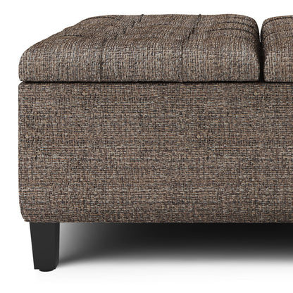 Close-up of the Harrison Upholstered Coffee Table Storage Ottoman, featuring textured brown fabric, a rectangular shape, black wooden legs, and a lid slightly raised to reveal storage space.