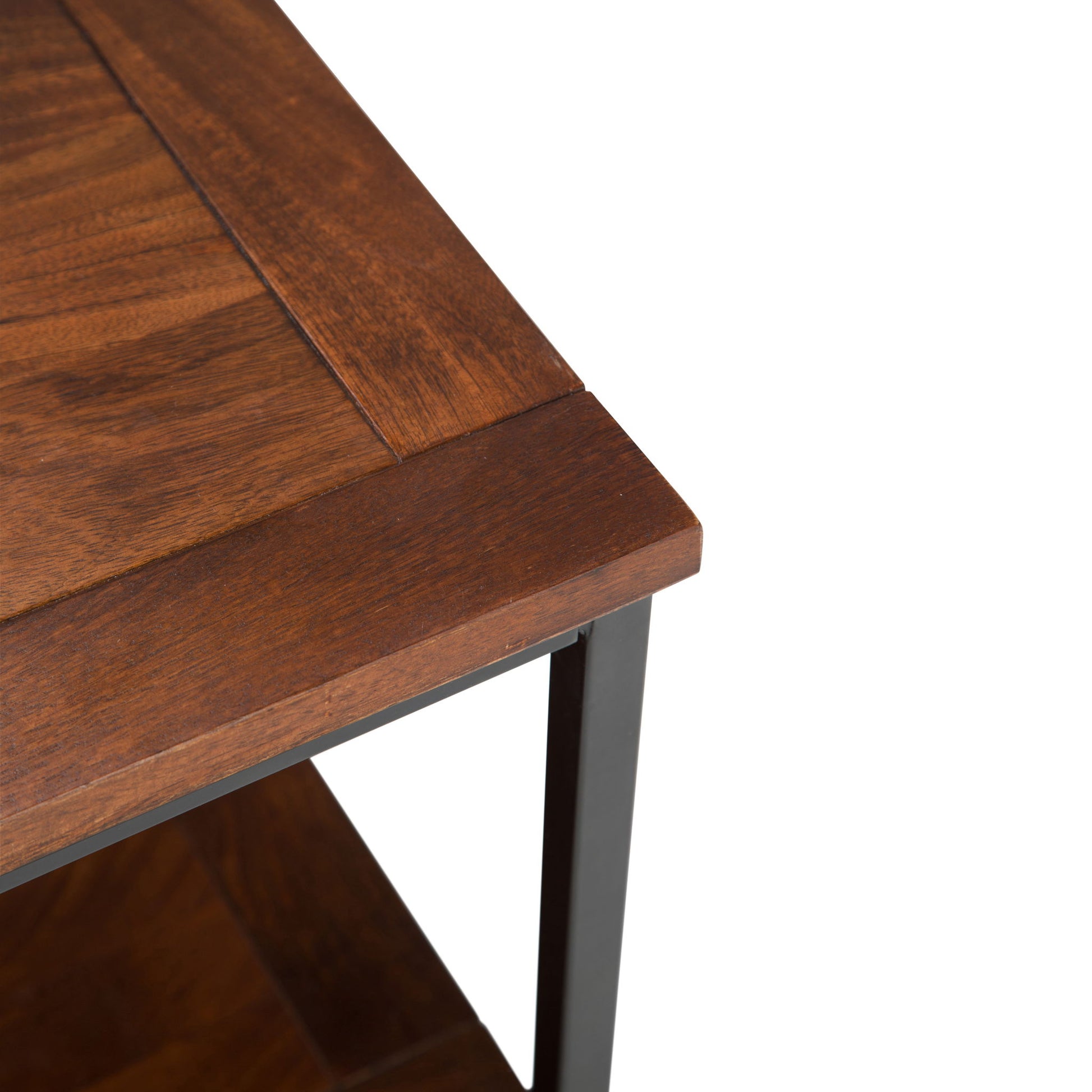 Close-up of the Skyler - Handcrafted Table's corner, featuring a wooden top, dark metal frame, and lower shelf, set against a white background.