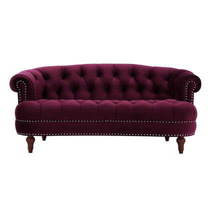 The La Rosa - Victorian Chesterfield Loveseat features deep purple velvet, rolled arms, button tufting, nailhead trim on the front, and dark wooden legs, shown against a white background.