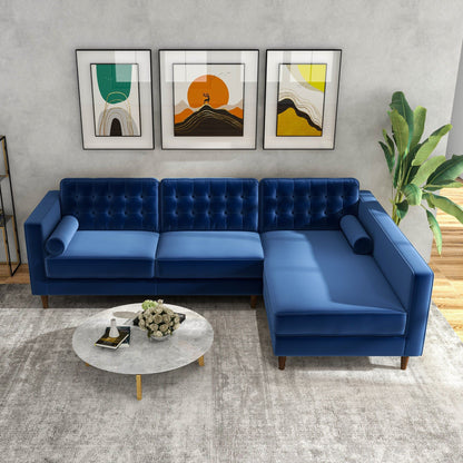 A modern living room featuring the Christian Mid-Century Modern Design Sectional Sofa in blue, a round marble coffee table, abstract wall art, a tall green plant, and a light-colored area rug.