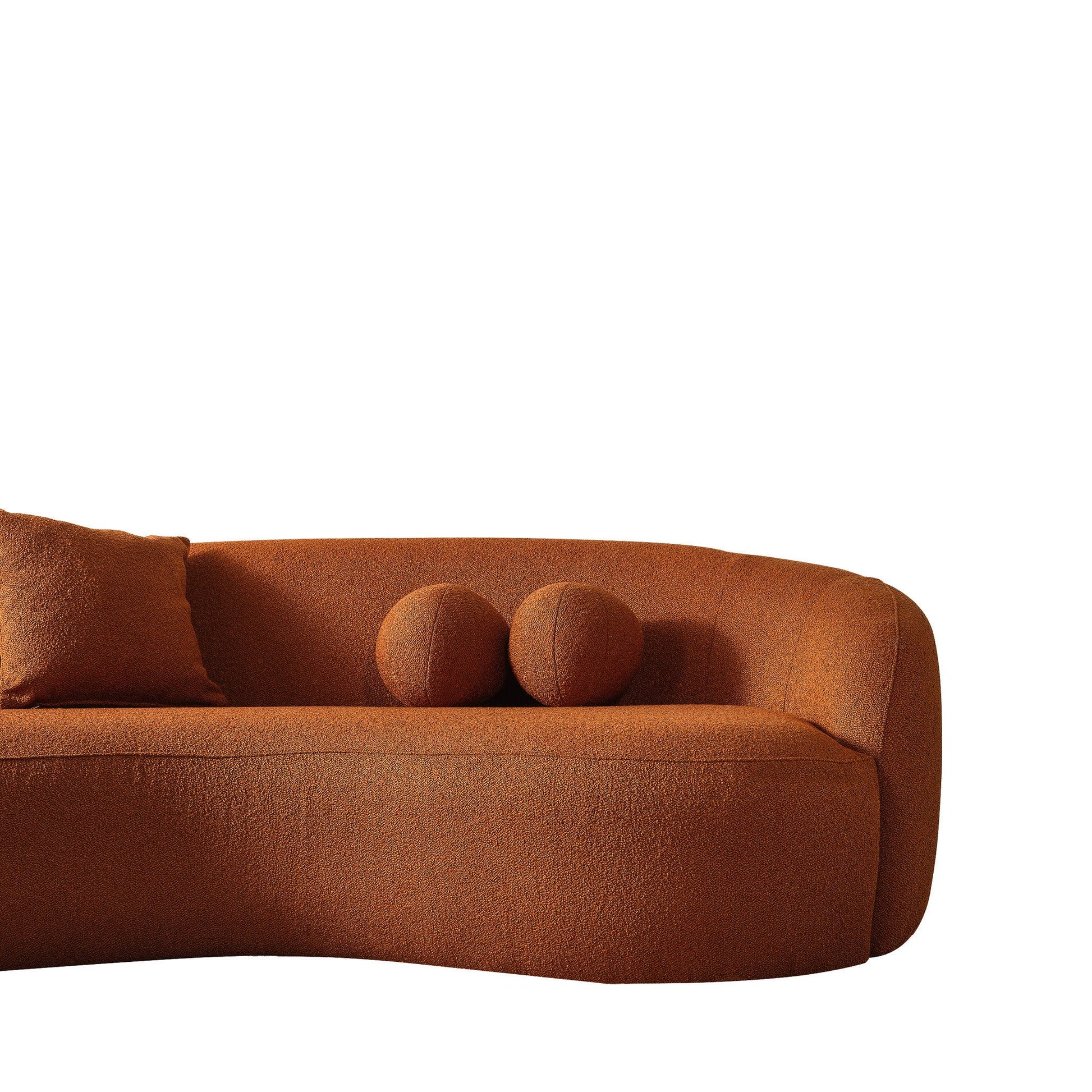 The Drake - Japandi Style Curvy Boucle Sofa, upholstered in rust fabric, includes a matching throw pillow and two spherical cushions, all displayed against a plain white background.