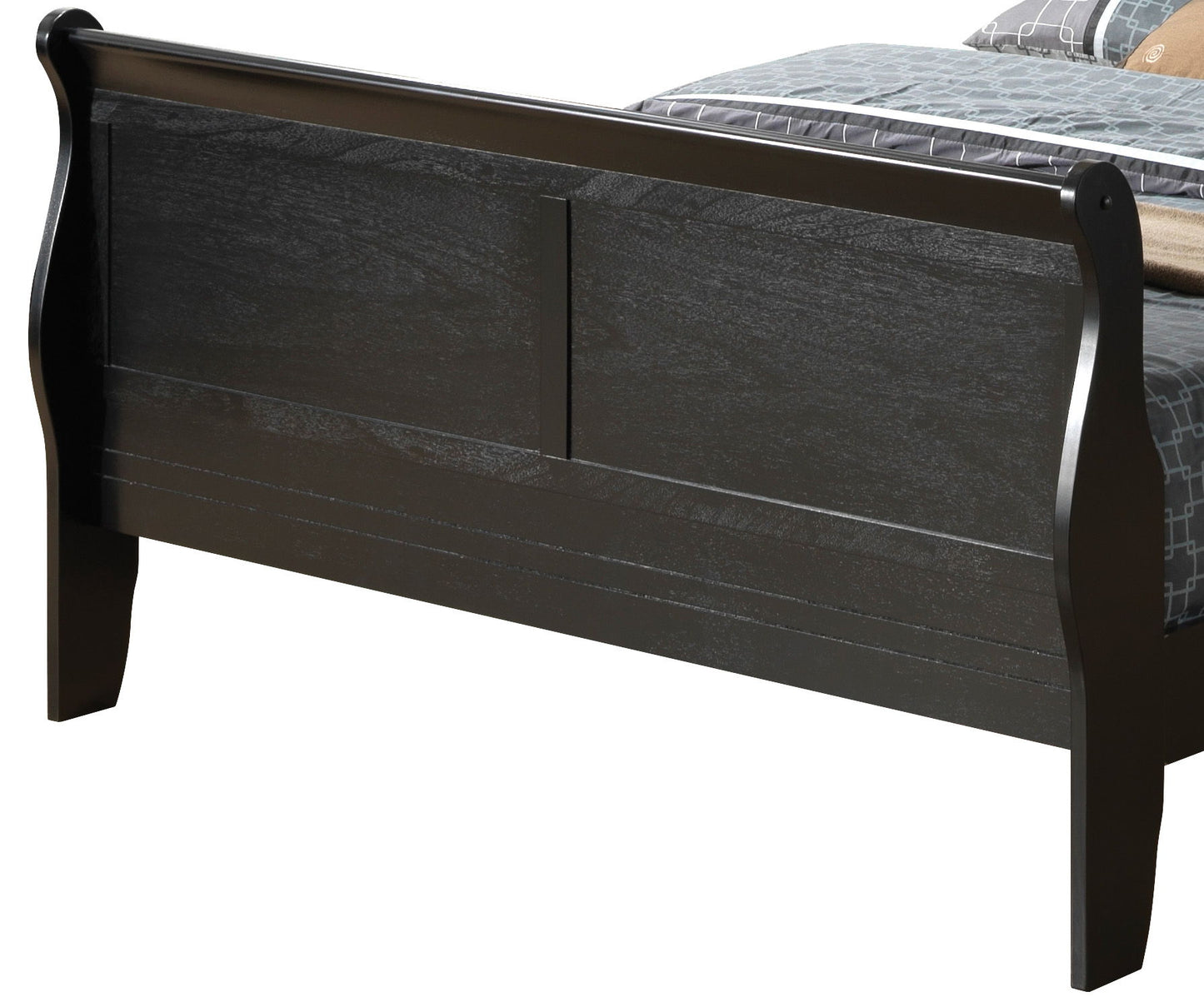 A close-up of the Panel Sleigh Bed's dark wooden frame highlights its sleigh-style footboard with curved edges and visible grain, partially showing a made bed with patterned bedding.