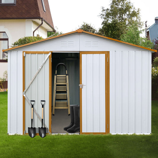 A 10' x 12' Garden Sheds Outdoor Storage Shed with open double doors shows a folded ladder and black rubber boots inside, while two shovels rest against the front. The shed stands on green grass near a house.