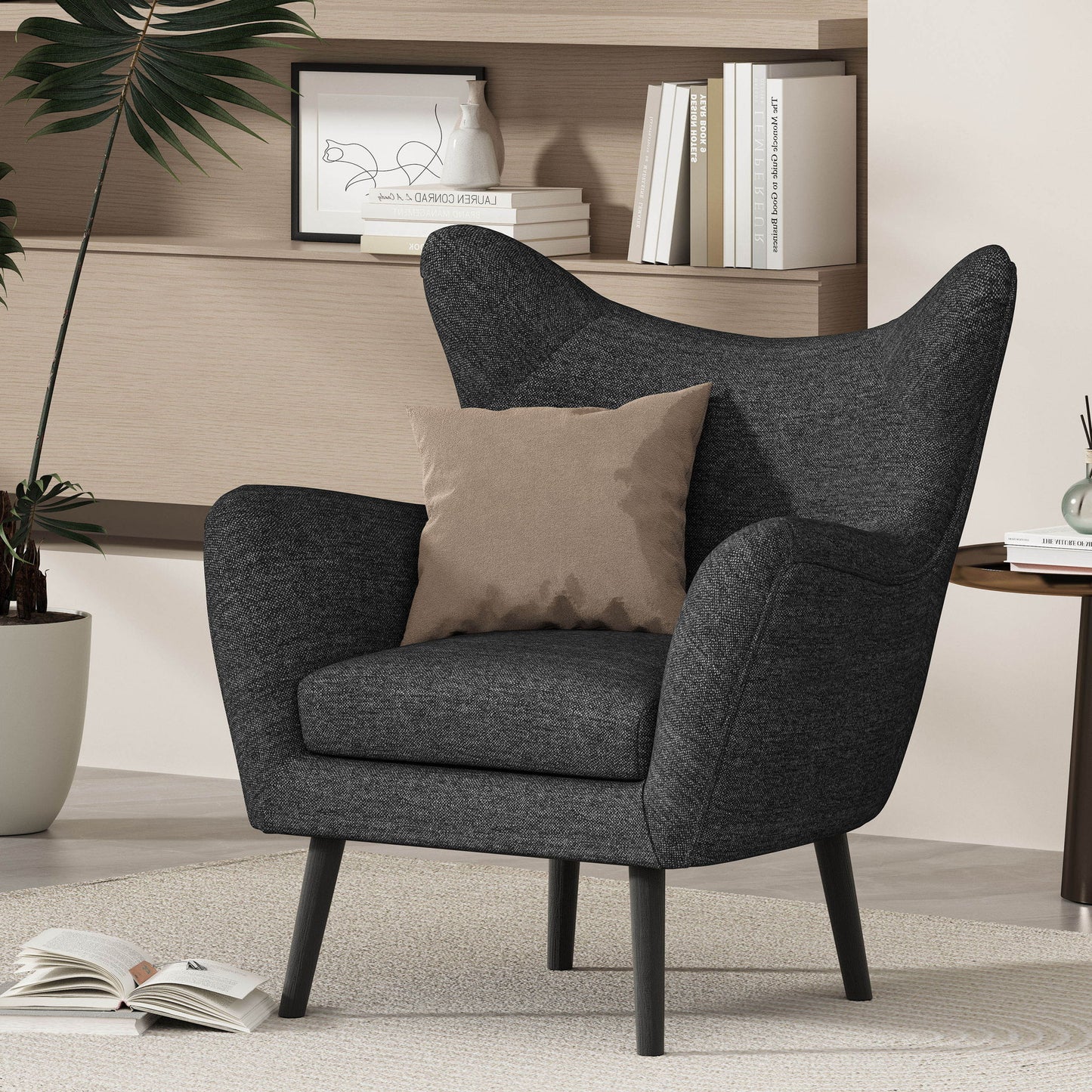 The Mid-Century Modern Arm Chair with wingback design and wood legs in dark gray with a beige cushion sits on a light rug. An open book is on the floor, surrounded by shelves, books, and a plant in the background.
