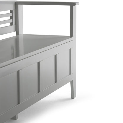 A close-up of the Adams - Entryway Storage Bench Handcrafted, featuring modern gray wood, panel detailing, armrests, and a flat seat, set against a white background.