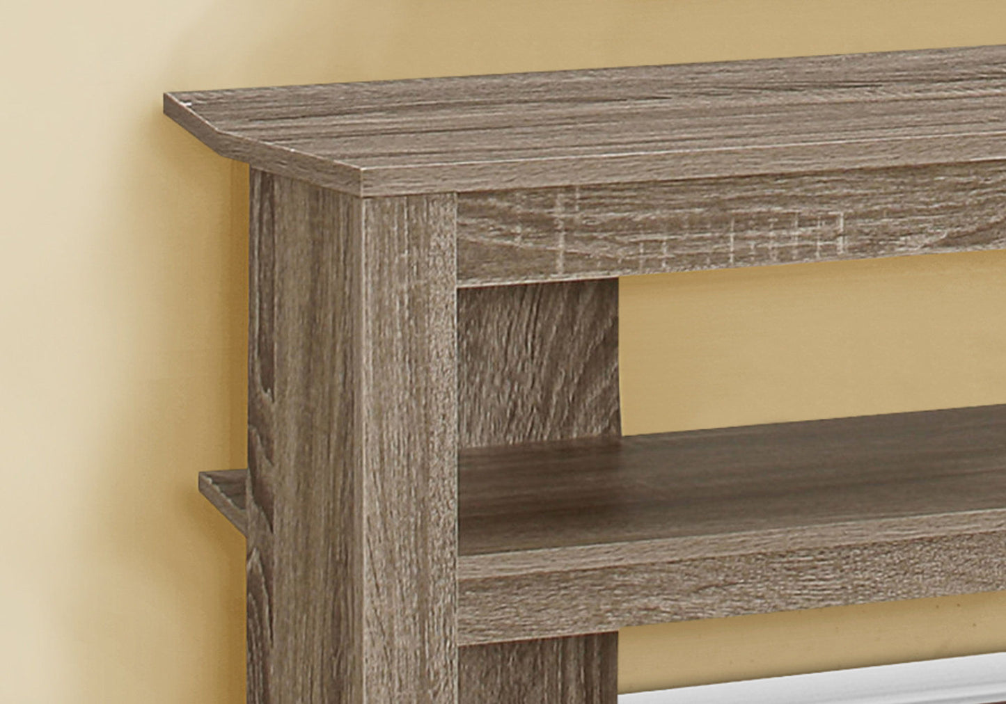 A close-up of the TV Stand, Console, Media Entertainment Center shows its rustic wood finish and two of its three clean-lined storage shelves, positioned against a light yellow wall.