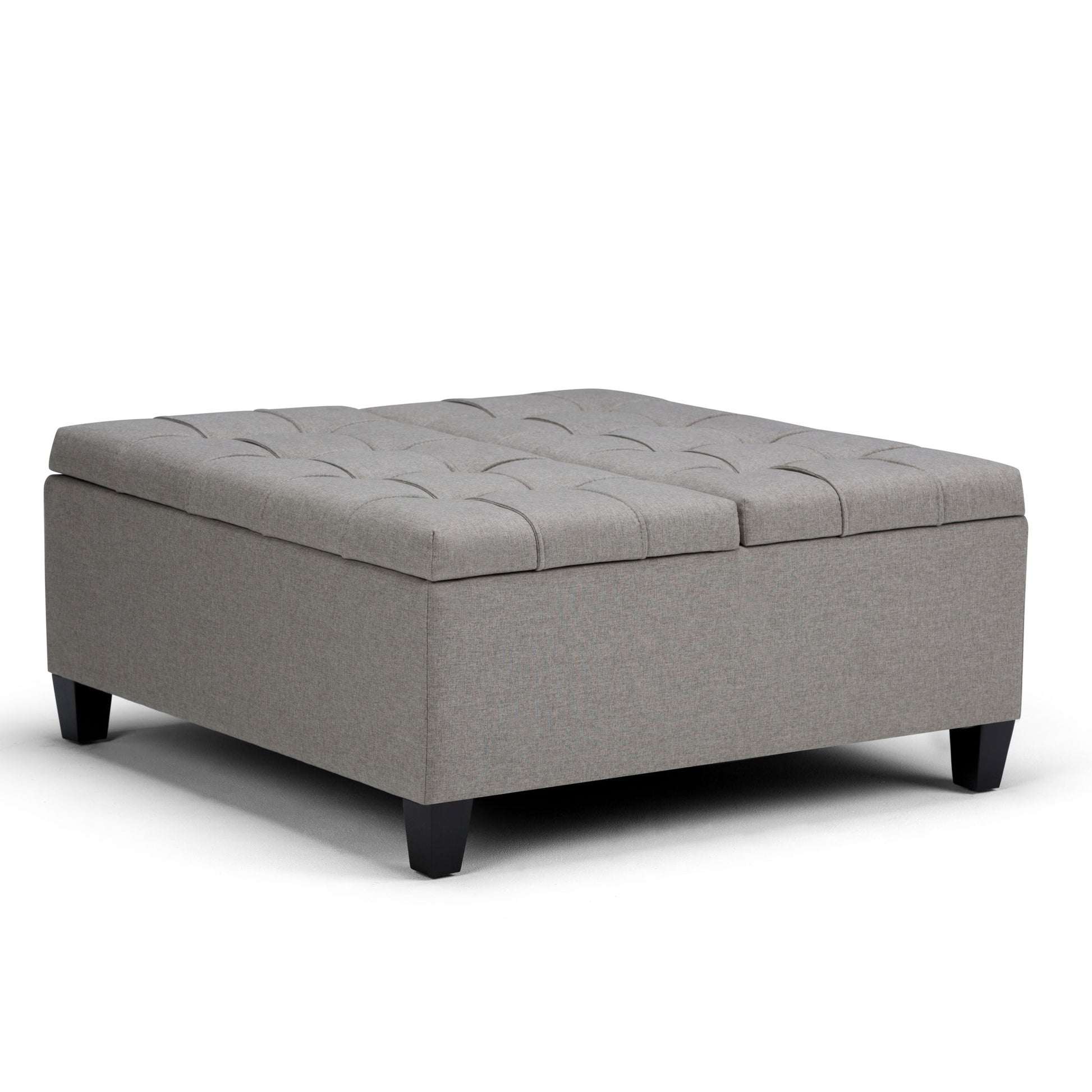 The Harrison - Upholstered Coffee Table Storage Ottoman features a large, square design in light gray with tufted top detailing and short black legs, shown on a white background.