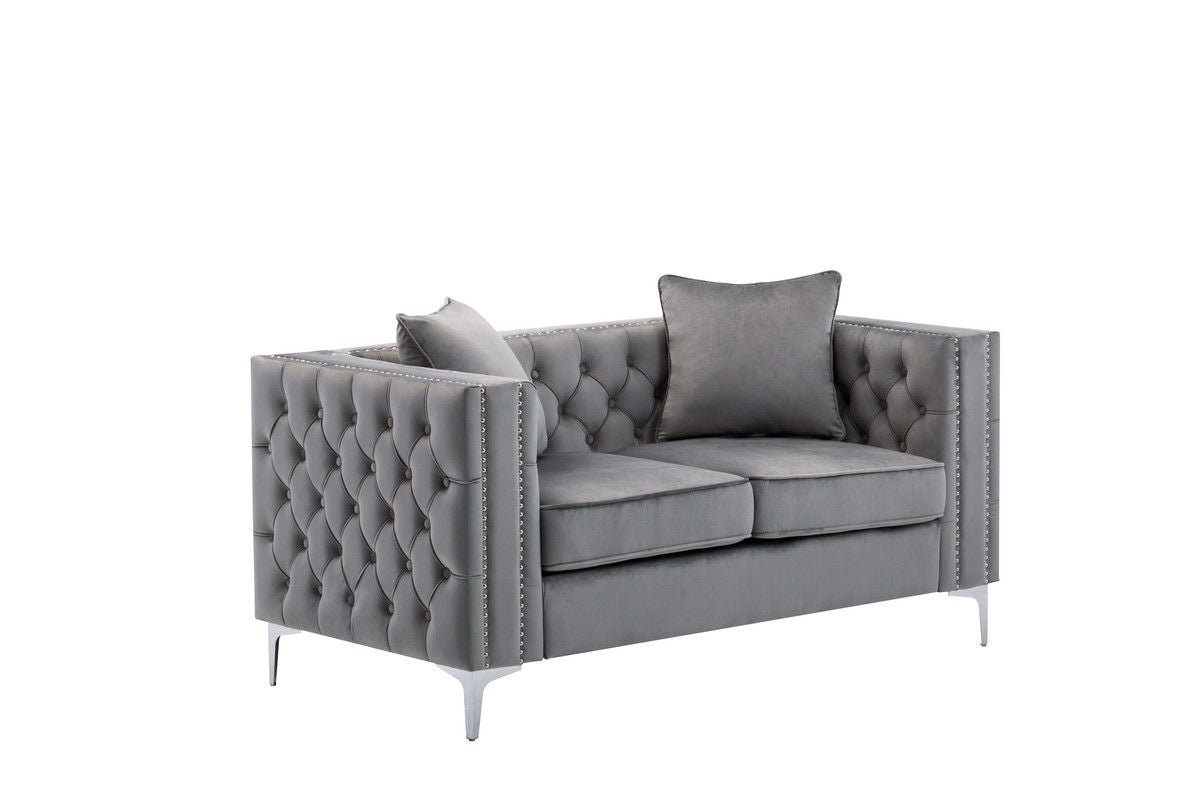 The Lorreto Velvet Loveseat features modern gray velvet upholstery, a tufted back and sides, silver nailhead trim, metal legs, and includes two matching gray cushions. Displayed against a white background.