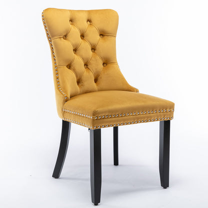 The Nikki set features two modern, high-end dining chairs upholstered in mustard yellow velvet with tufted backrests, silver nailhead trim, and dark solid wood legs, shown against a plain white background.